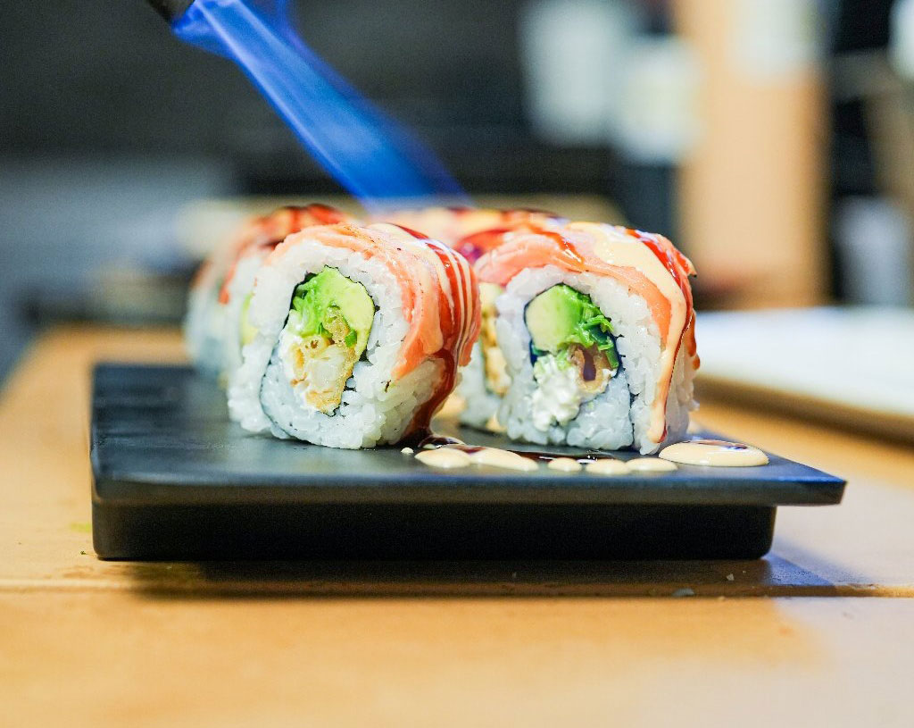 Flame-seared sushi rolls with creamy sauce