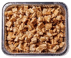 A foil tray filled with small, chopped pieces of cooked chicken seasoned with spices, displayed from a top-down view. The chicken pieces are golden brown and neatly arranged in the tray.